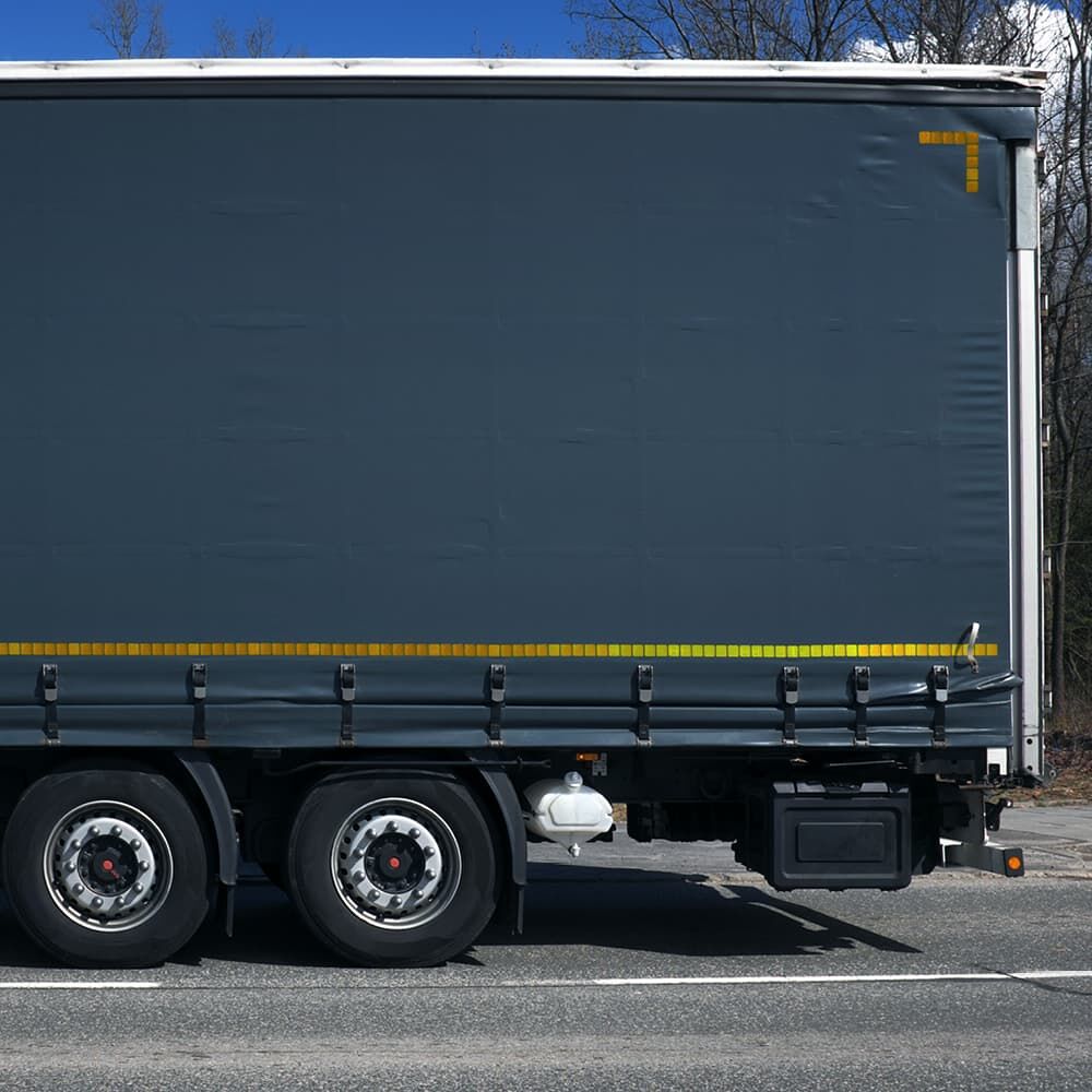 Gelbe reflektierende Konturmarkierung auf Lkw mit dunkelgrauer Plane