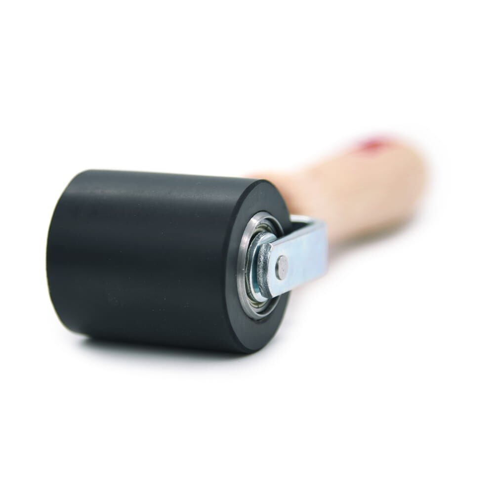 Nahaufnahme der Andruckwalze mit schwarzer Rolle und Metallhalterung