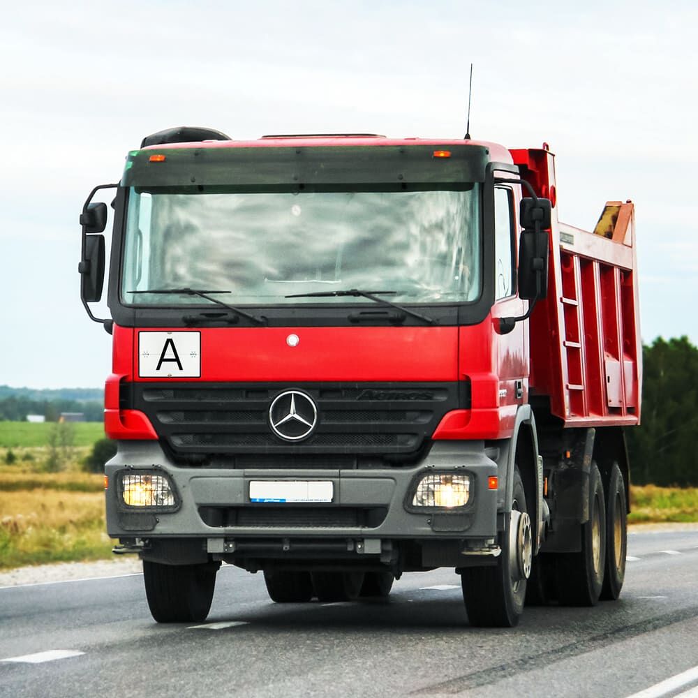 A-Schild horizontal am roten Lkw montiert, zeigt Einsatz im Straßenverkehr.