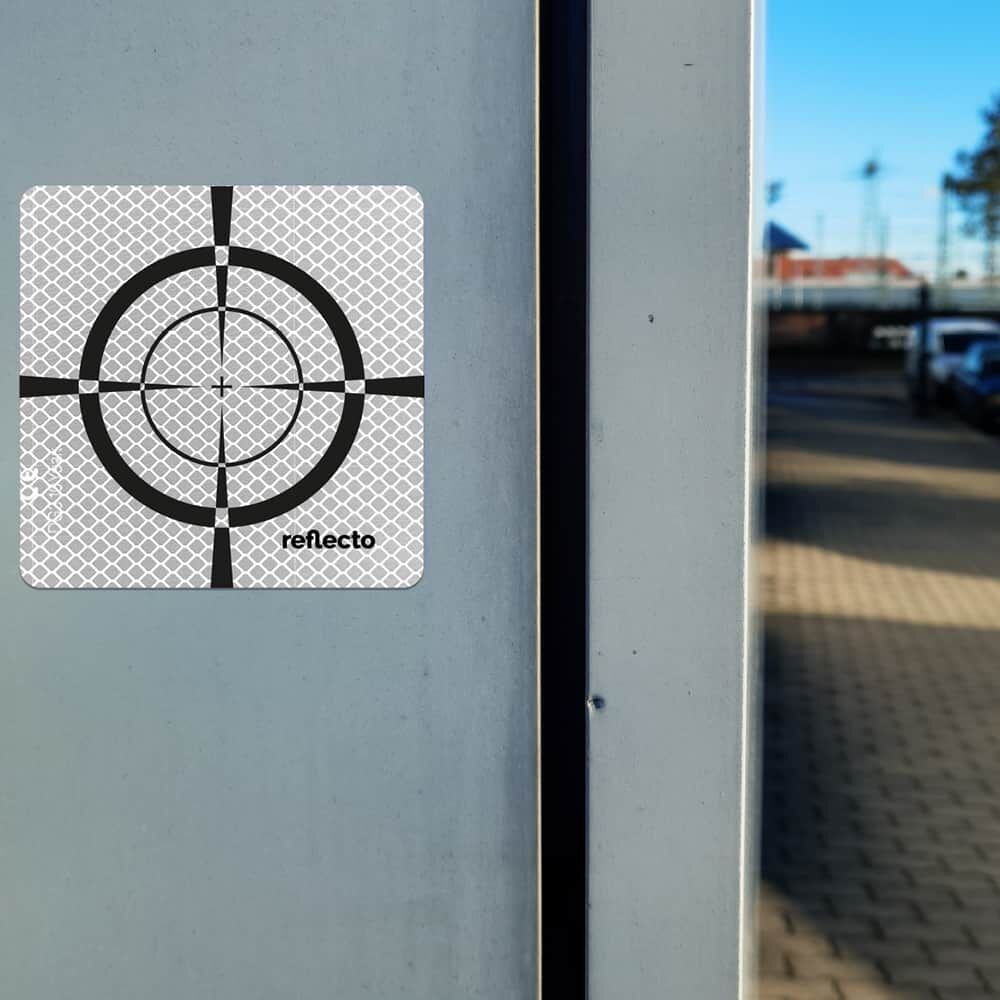Zielmarke auf glatter Betonsäule im urbanen Umfeld, ideal für Vermessungspunkte