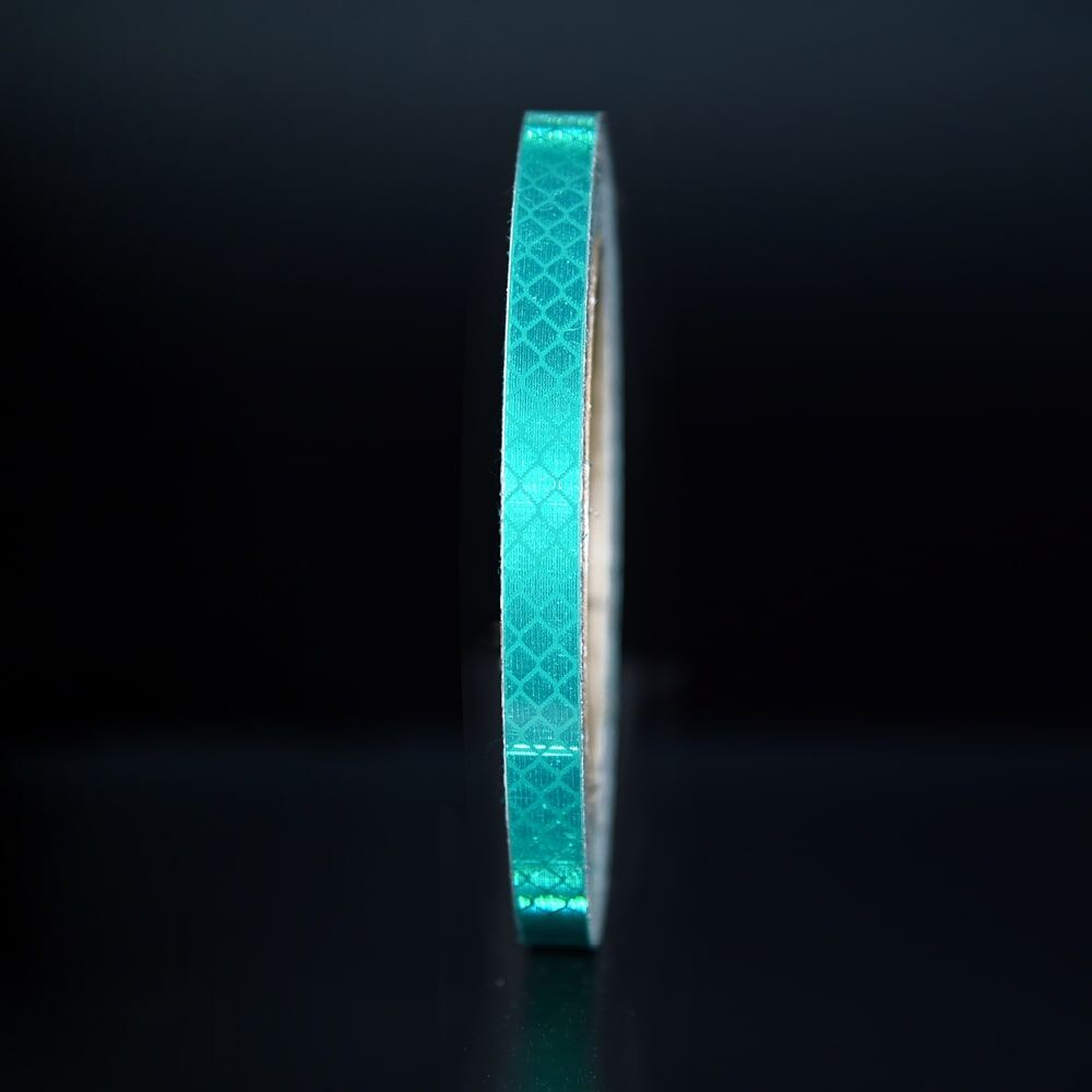10 mm Rolle 3M Reflexband 4090 grün, reflektierend vor dunklem Hintergrund