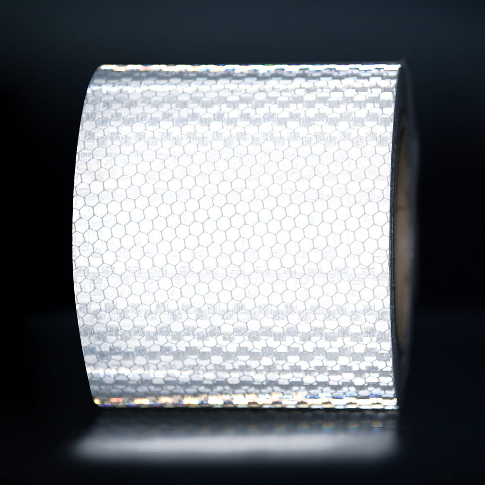 100 mm Rolle Avery Reflexband T-11500 OmniCube weiß, reflektierend vor dunklem Hintergrund