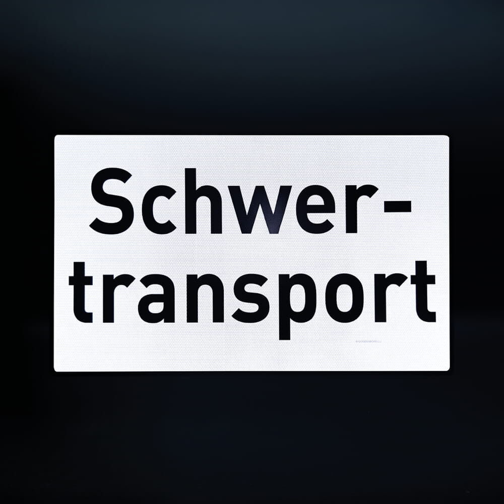 Reflektierendes Schild „Schwertransport“ vor dunklem Hintergrund