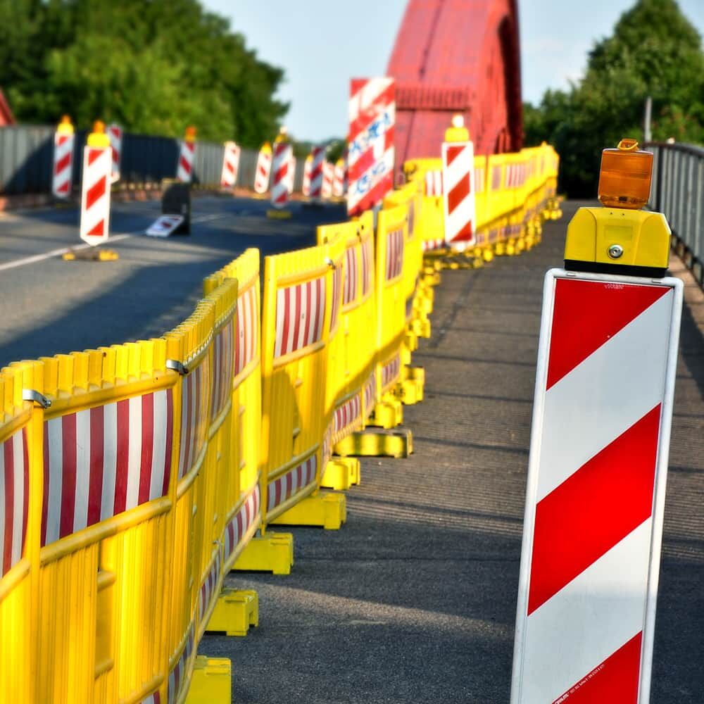 Baustellenszene: gelbe Absperrung und Leitbake mit Orafol 5831 Reflexfolie rot-weiß