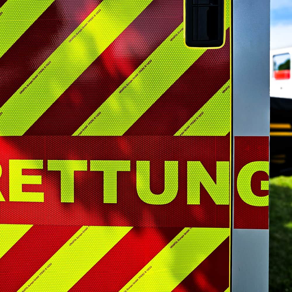 Heck eines Rettungswagens mit gelb-roten VC 612 Chevron-Streifen und Schriftzug „Rettung“