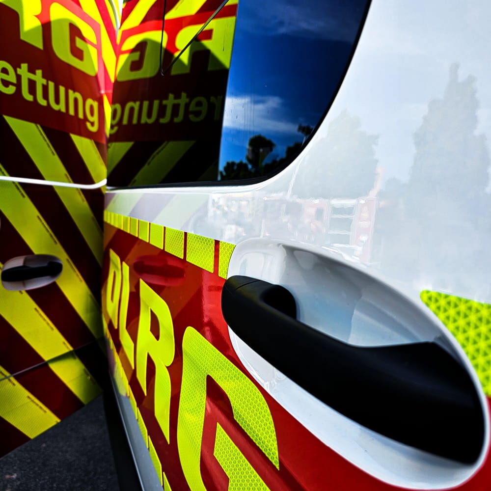 DLRG-Einsatzwagen: rot-gelbes Warnmuster mit stark reflektierendem Schriftzug