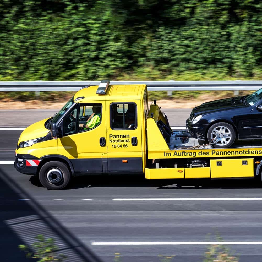 Anwendungsbeispiel: Textaufkleber auf gelbem Abschleppwagen im Einsatz