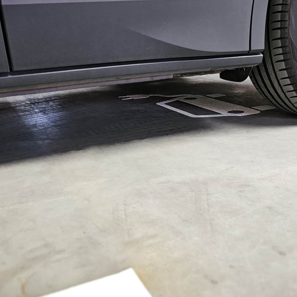 Elektroauto-Bodenmarkierung weiß unter parkendem Fahrzeug