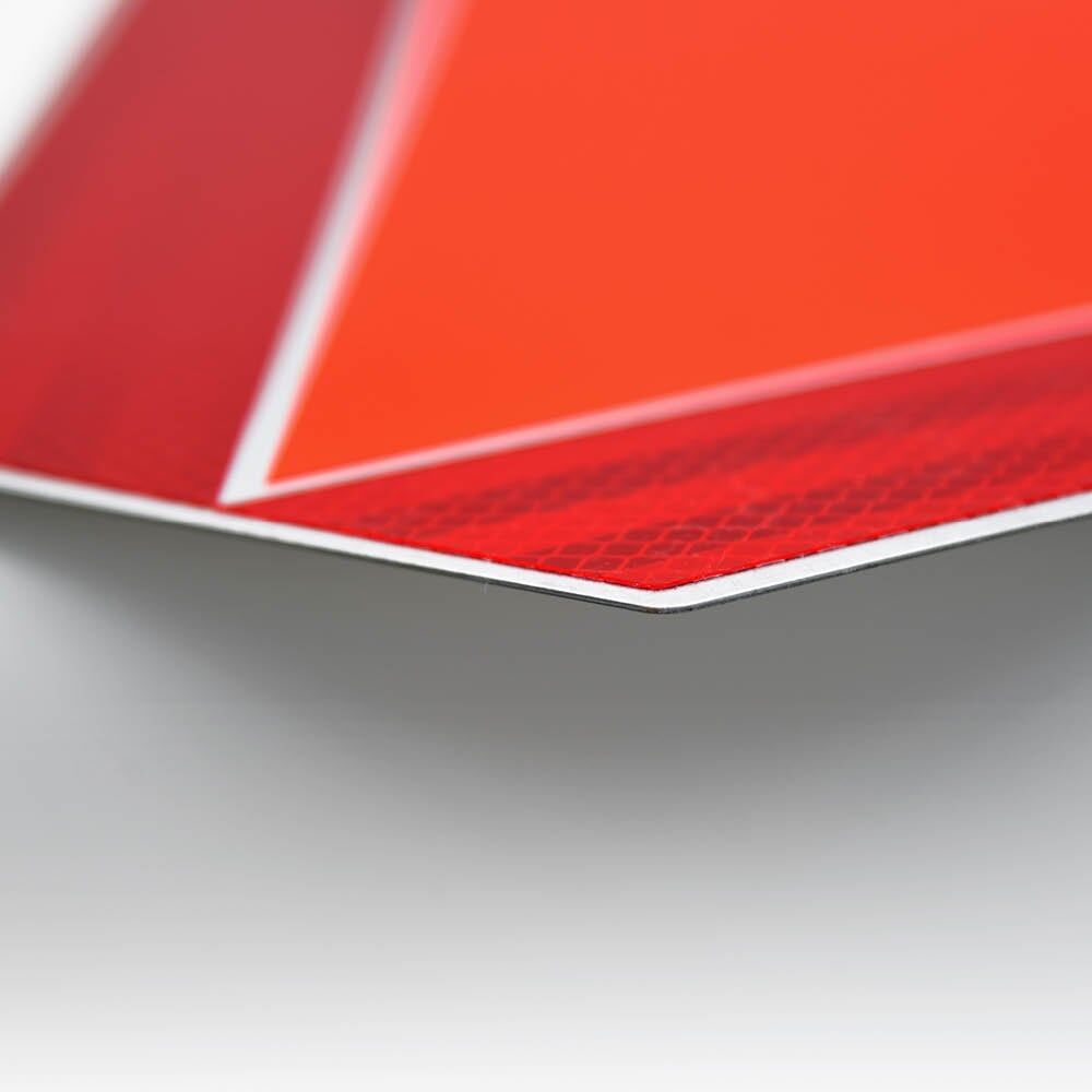 Detailansicht der Warntafel-Kante mit reflektierendem rotem Rand und oranger Fläche