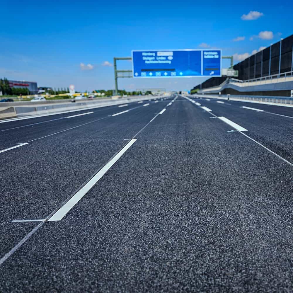 Gerade aufgebrachte weiße Markierungslinien auf mehrspuriger Autobahn
