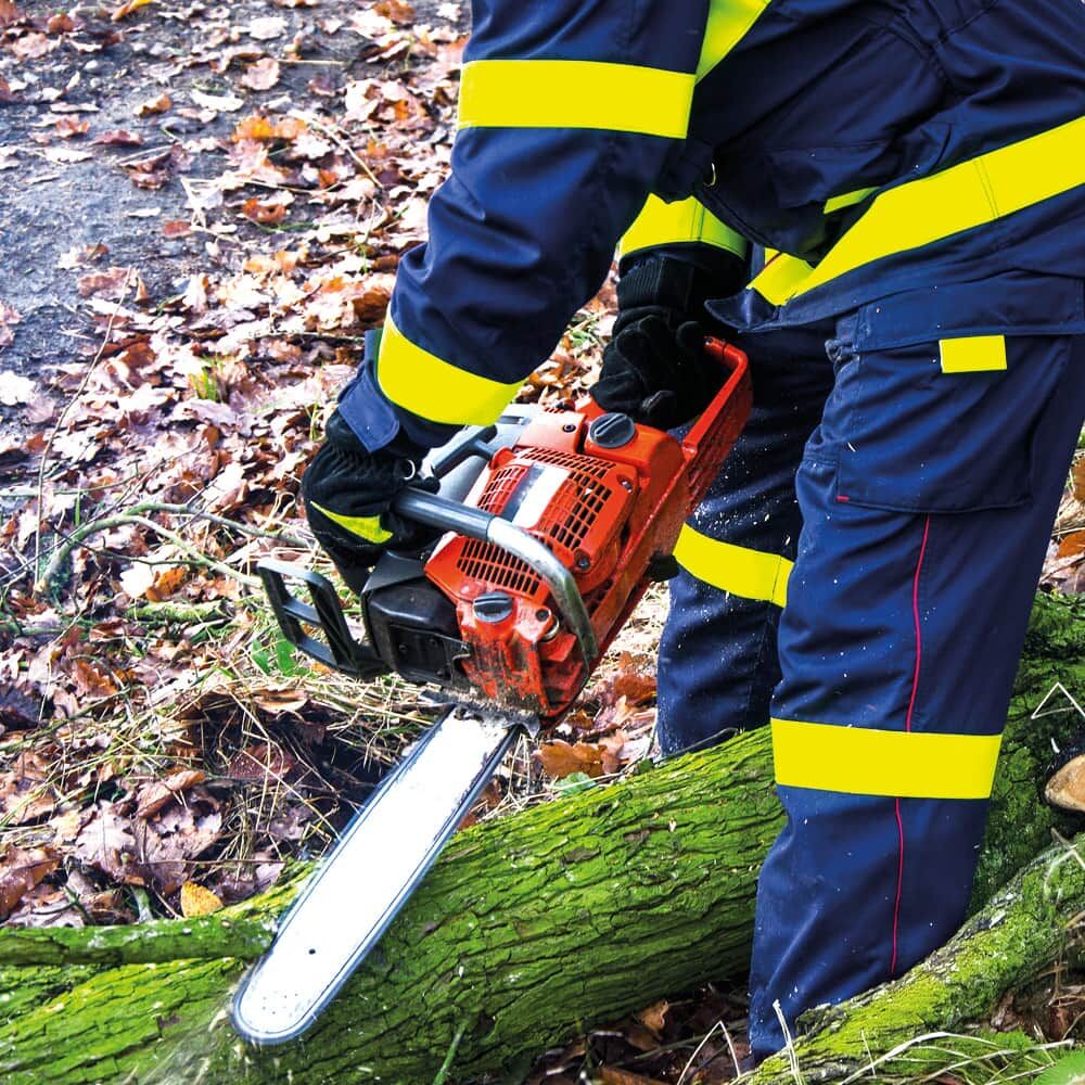 Einsatzkraft sägt Baumstamm, auffällige gelbe 3M Scotchlite 8987 Reflexbänder an Jacke und Hose