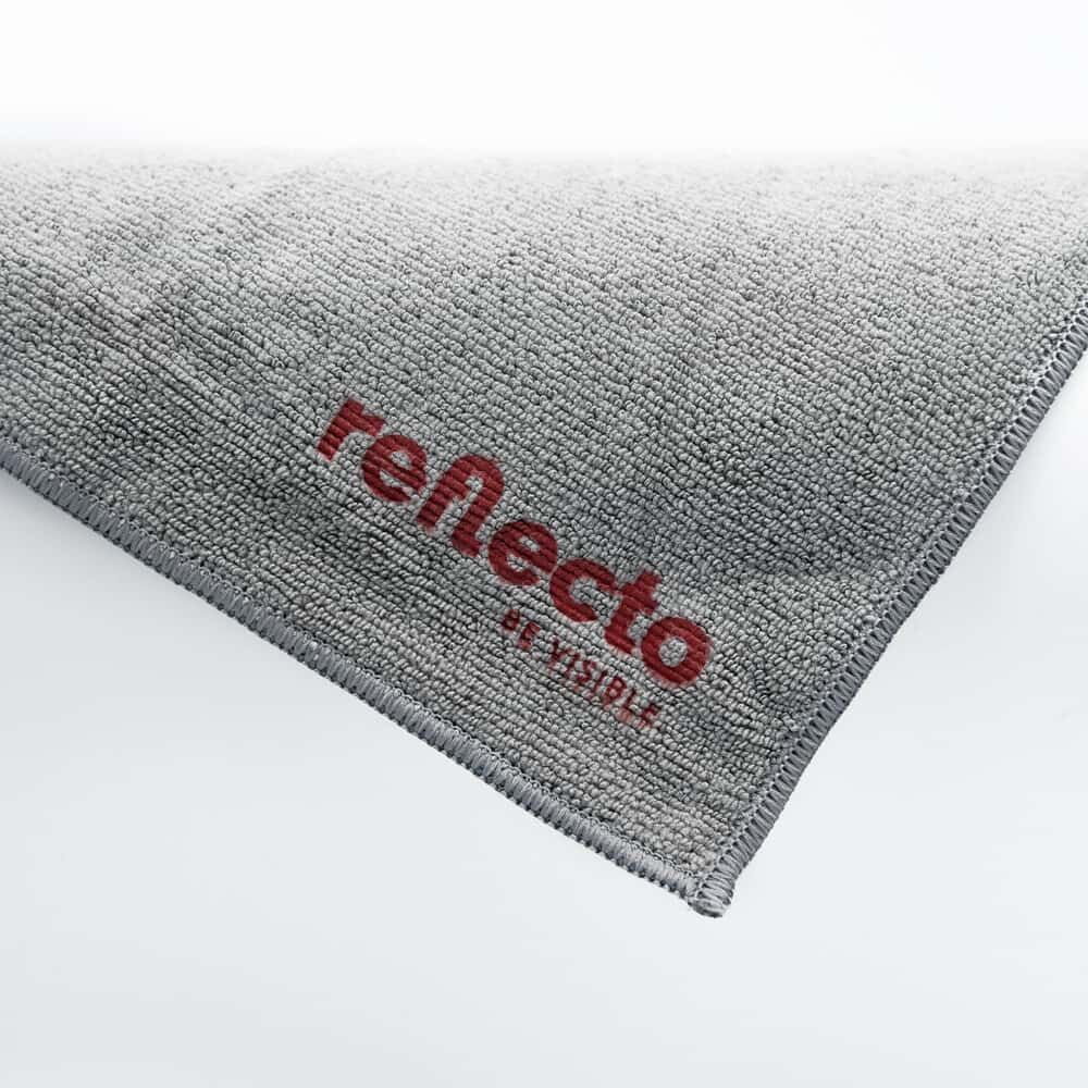 Diagonal gelegte Ecke mit rotem reflecto-Logo auf grauem Microfasertuch.