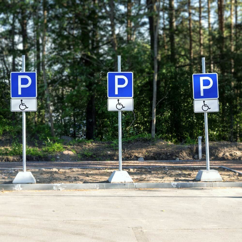 Anwendungsbeispiel: mehrere „P“-Parkplatzschilder mit Rollstuhl-Symbol auf Pfosten