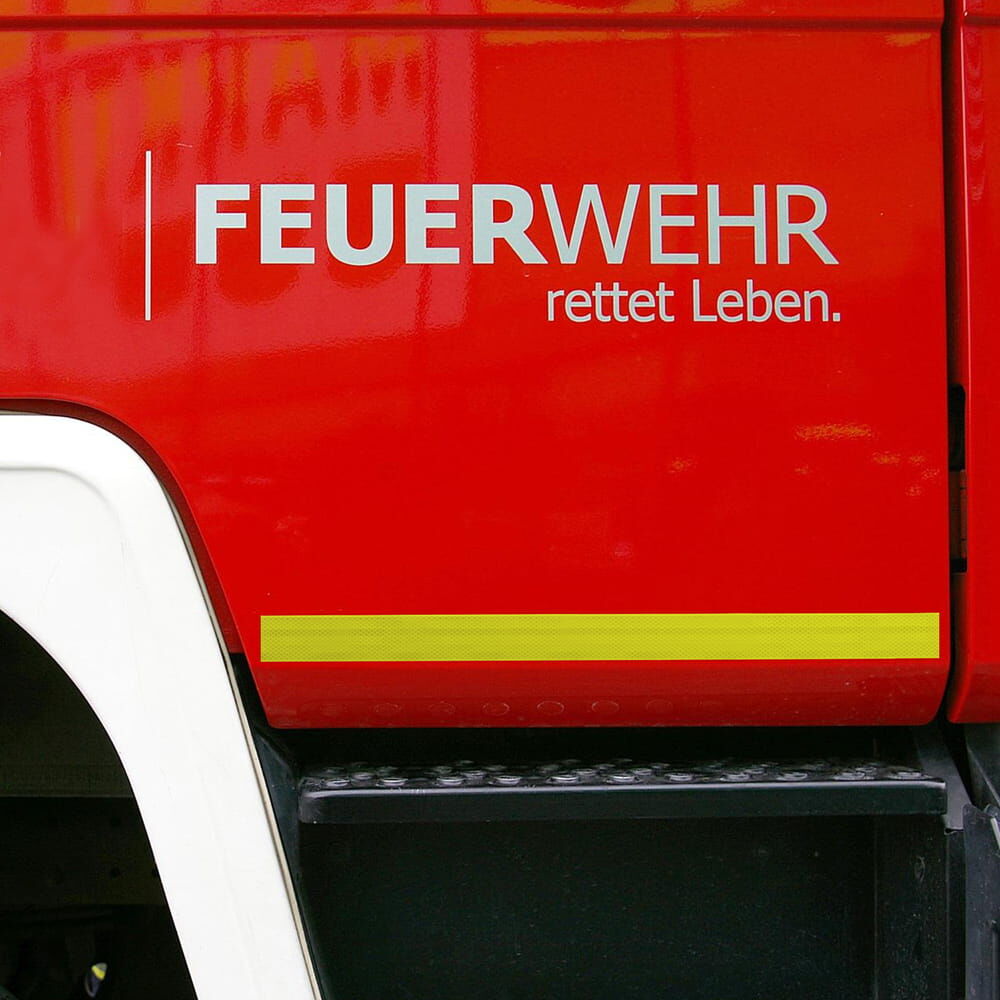 Feuerwehr­fahrzeug mit horizontalem 3M 983 Konturstreifen fluor-lime unter Schrift