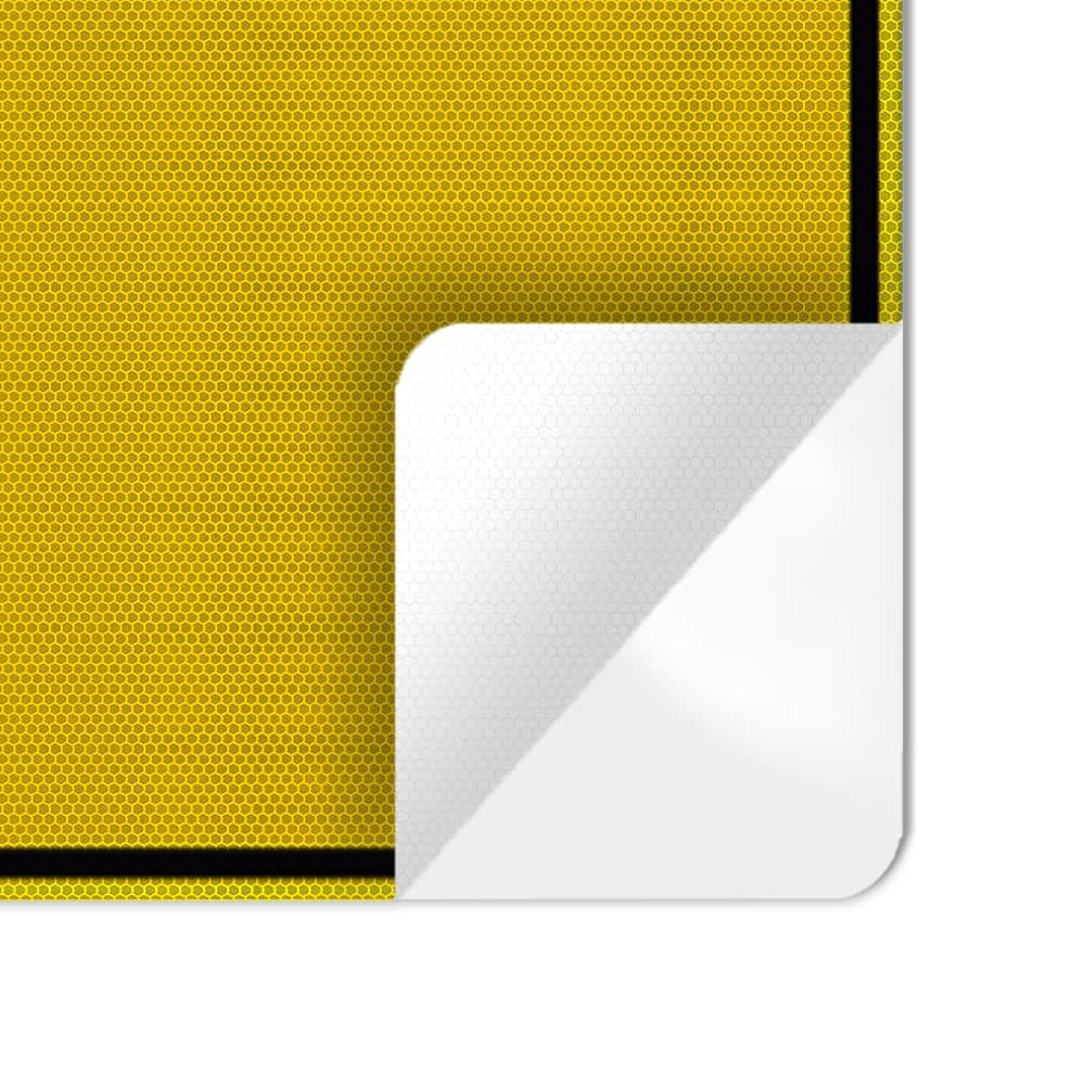 Nahaufnahme: abgelöste Ecke der gelben Wabenfolie, schwarzer Rahmen und Kleberückseite