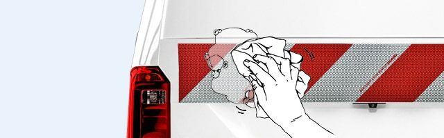 Reinigung von Reflexfolien Eine Illustration, die das Reinigen oder Abwischen einer rot-weißen Warnmarkierung zeigt.