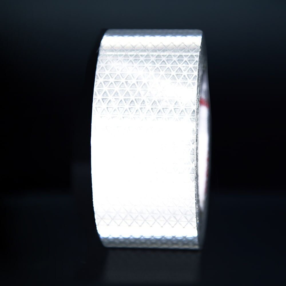 50 mm Rolle Orafol Reflexband 5930MFlex weiß, reflektierend vor dunklem Hintergrund