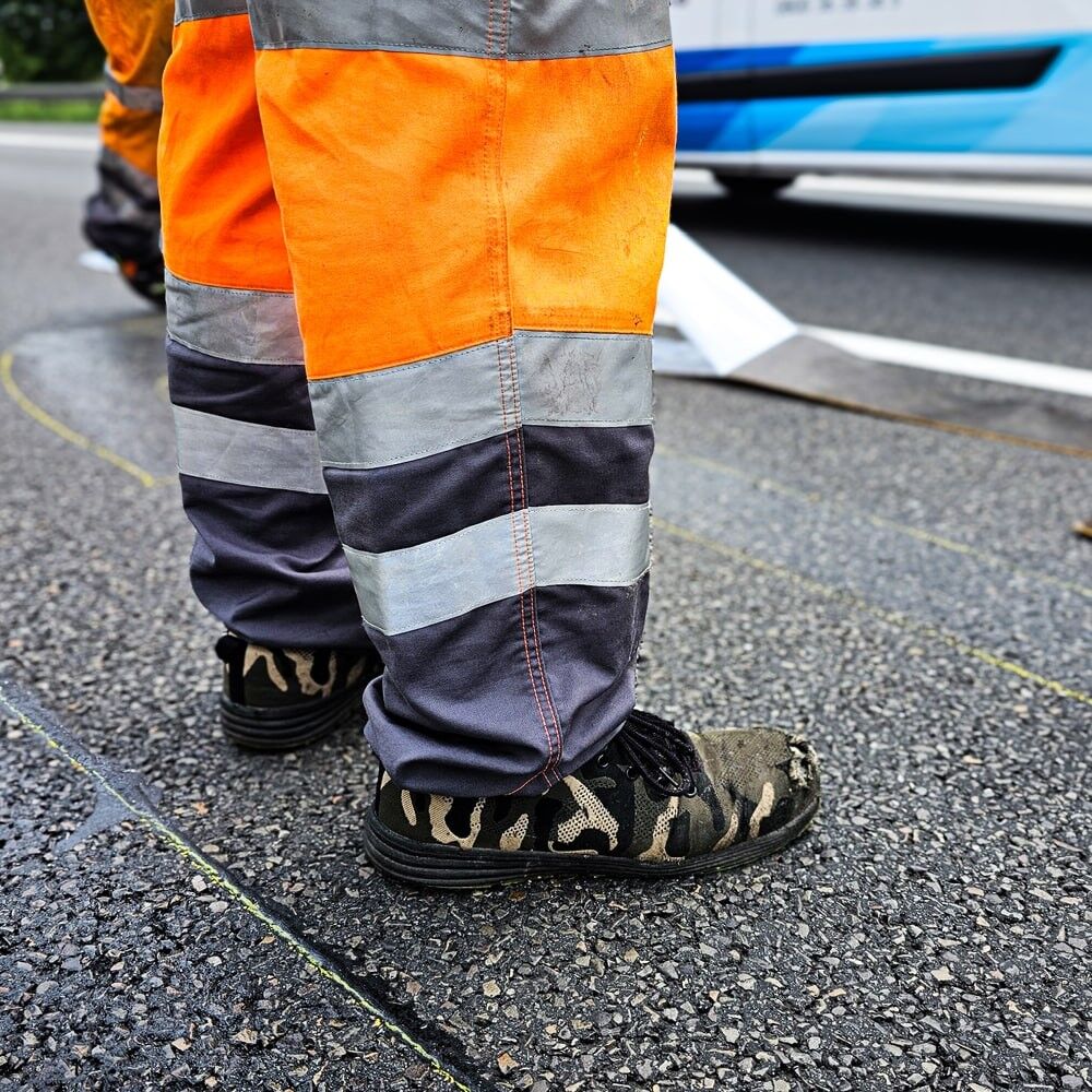 Arbeitshose mit silbernen 3M Scotchlite 8925 Reflexstreifen bei Straßenarbeiten
