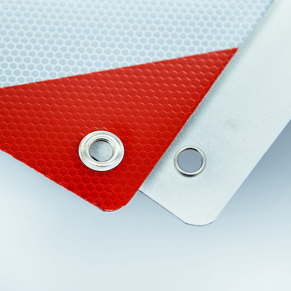Detail: Öse und Befestigungsloch an Warntafel und Aluminiumrückseite