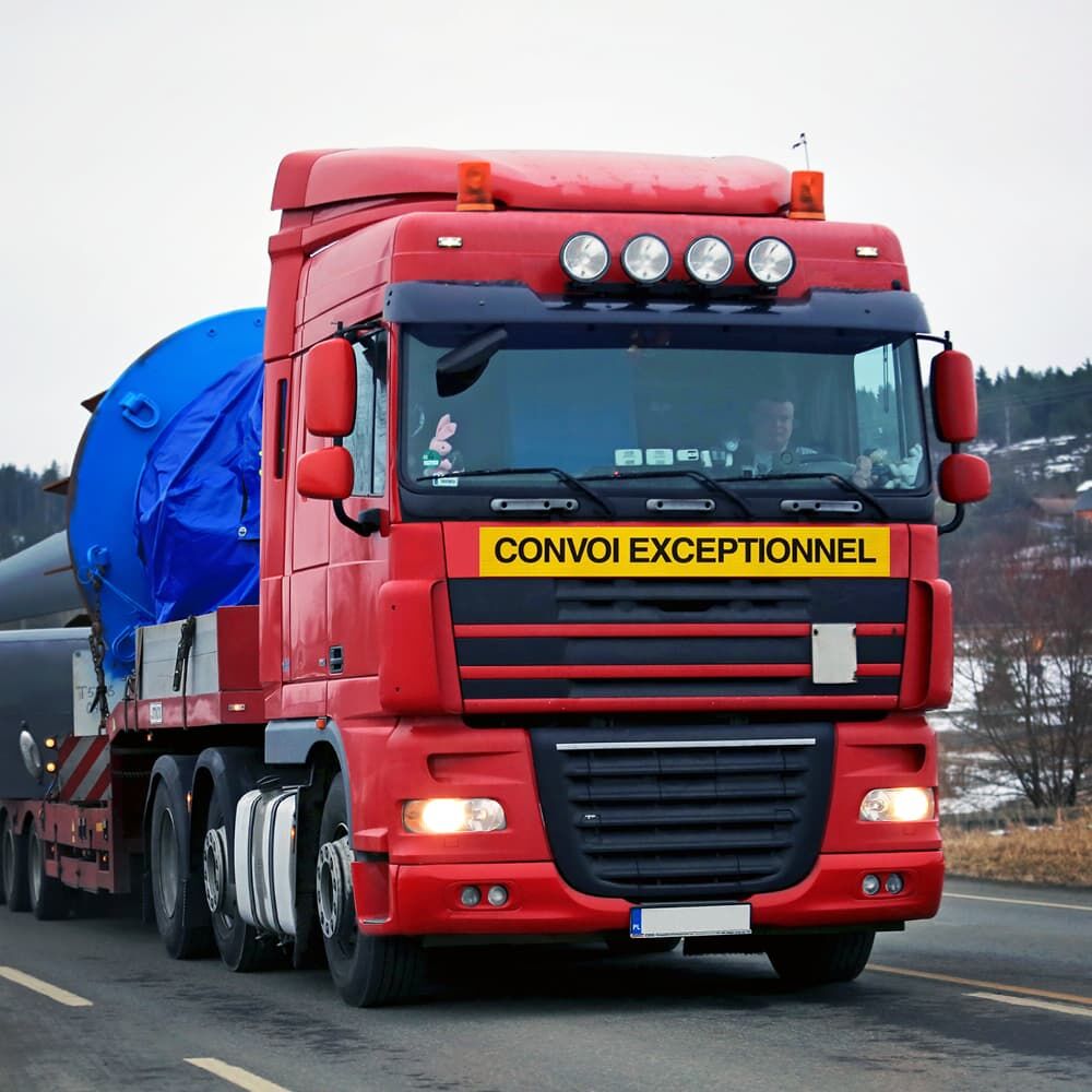 Montierte Warntafel "CONVOI EXCEPTIONNEL" an rotem Schwertransportfahrzeug vorne