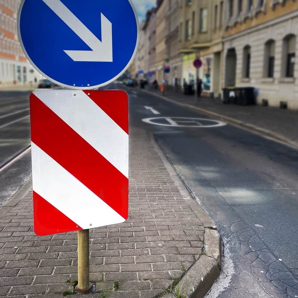 Leitplatte VZ 626-20 links unter blauem Pfeilschild auf Fußgängerinsel montiert