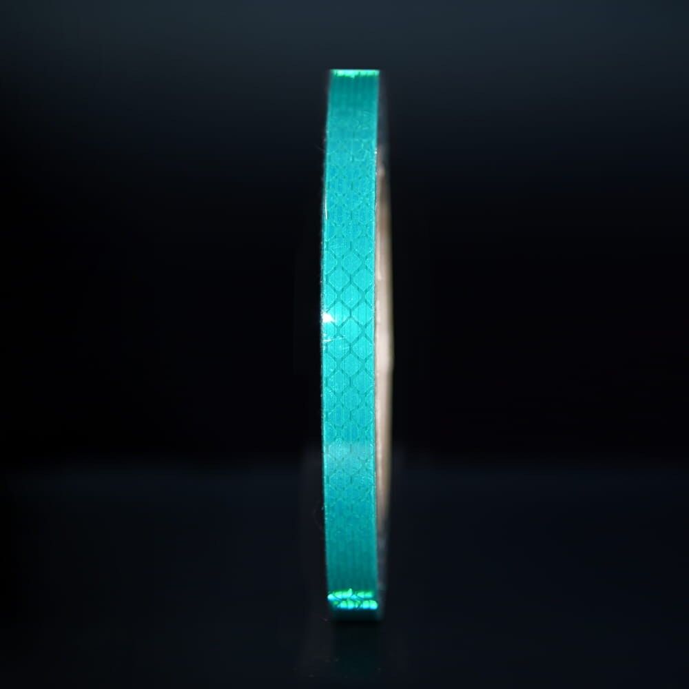 10 mm Rolle 3M Reflexband 3930 grün, reflektierend vor dunklem Hintergrund