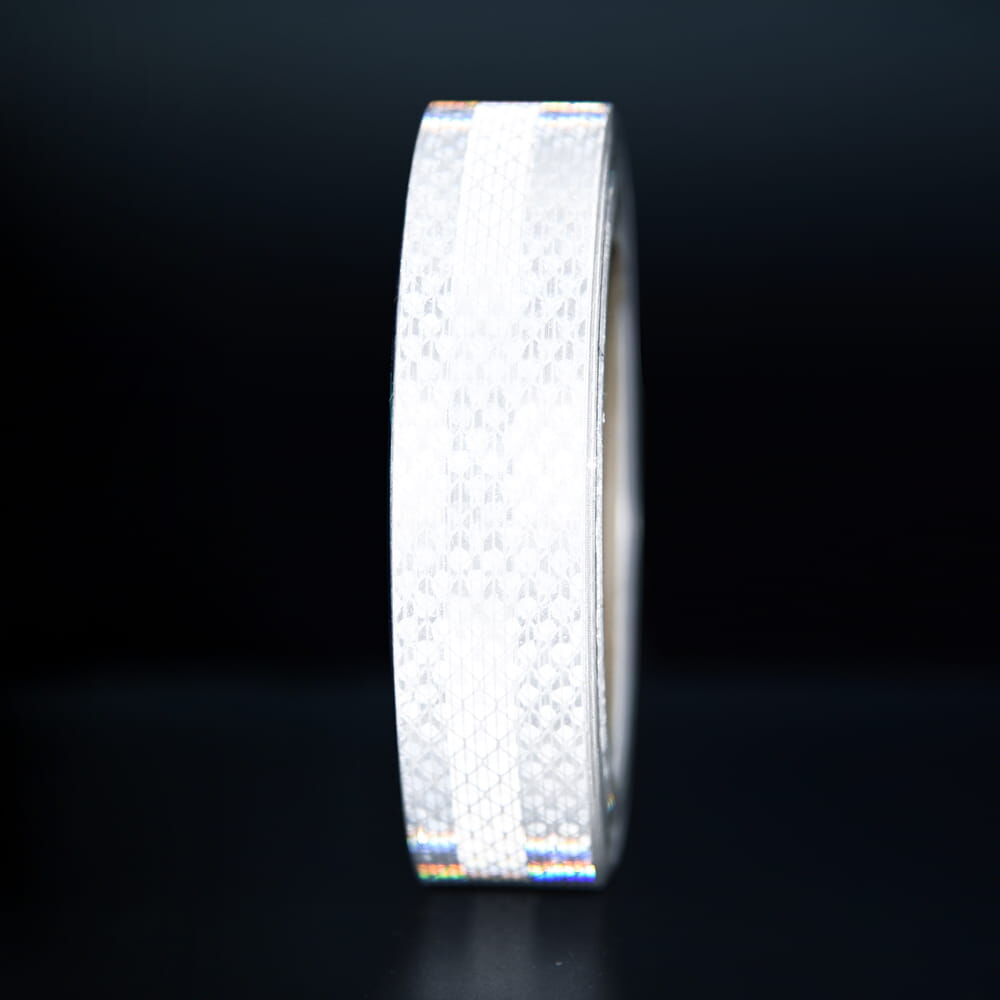 25 mm Rolle 3M Reflexband 3930 weiß, reflektierend vor dunklem Hintergrund