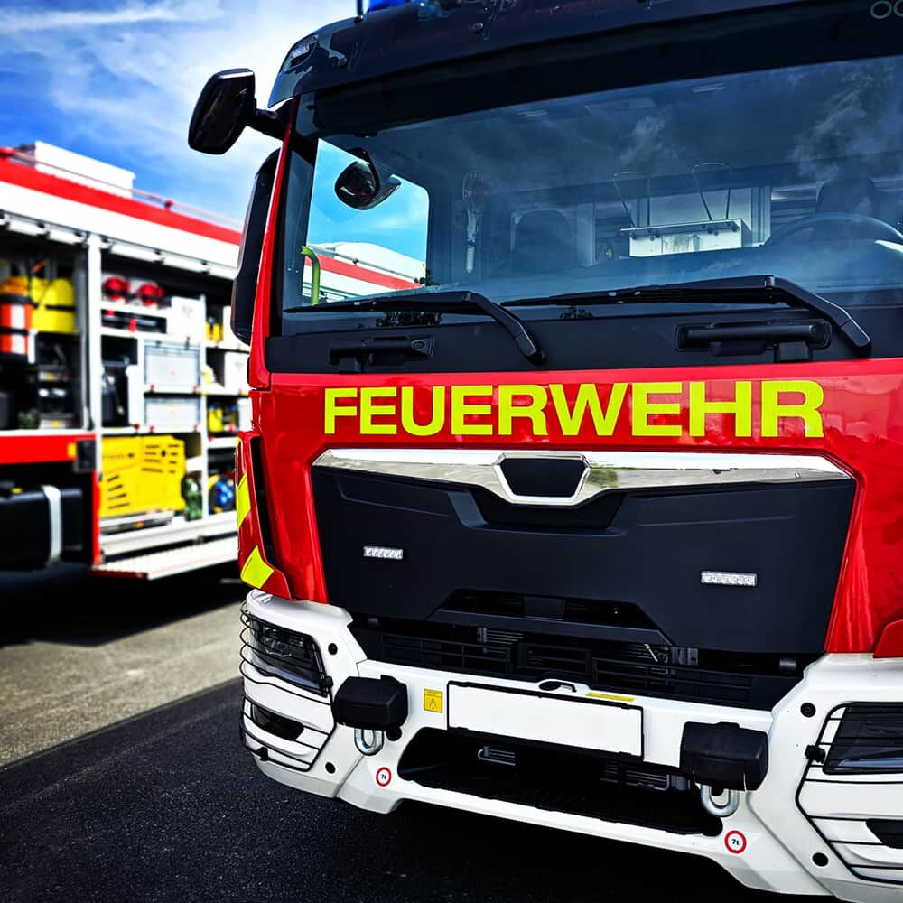 Front eines Feuerwehr-Löschfahrzeugs mit reflektierender Gelbschrift „FEUERWEHR“