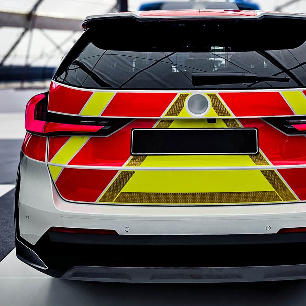 Heck eines Einsatzwagens mit rot-gelben Chevron-Warnflächen aus Fluorfolie 7710.