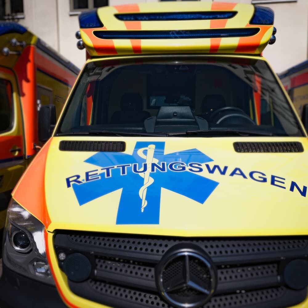 Zwei Rettungswagen mit ORALITE 5600E Warnbeklebung in Gelb, Blau und Orange