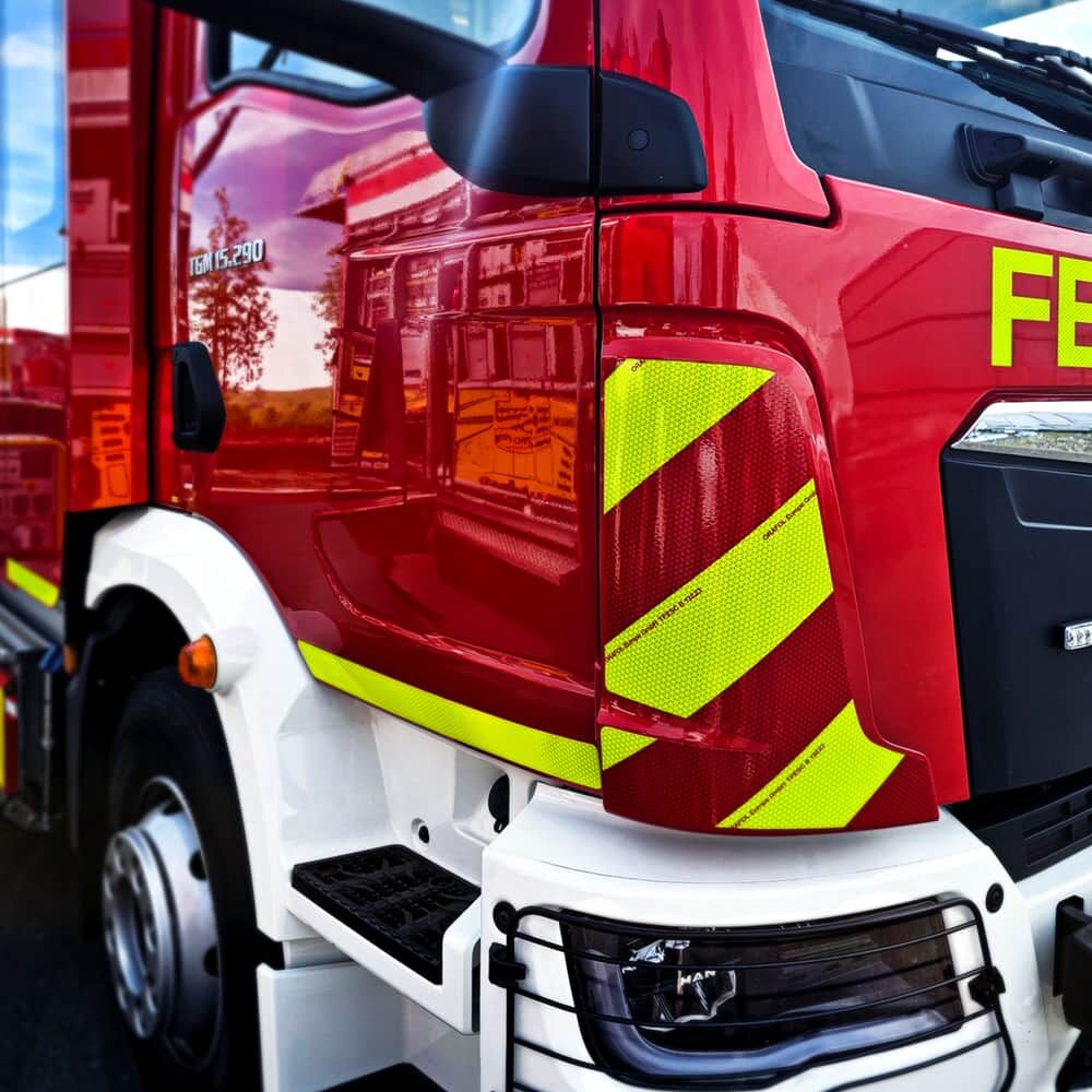 Seitliche ORALITE VC 612 Warnmarkierung fluorlime-rot an Säule einesFeuerwehr-Lkw.
