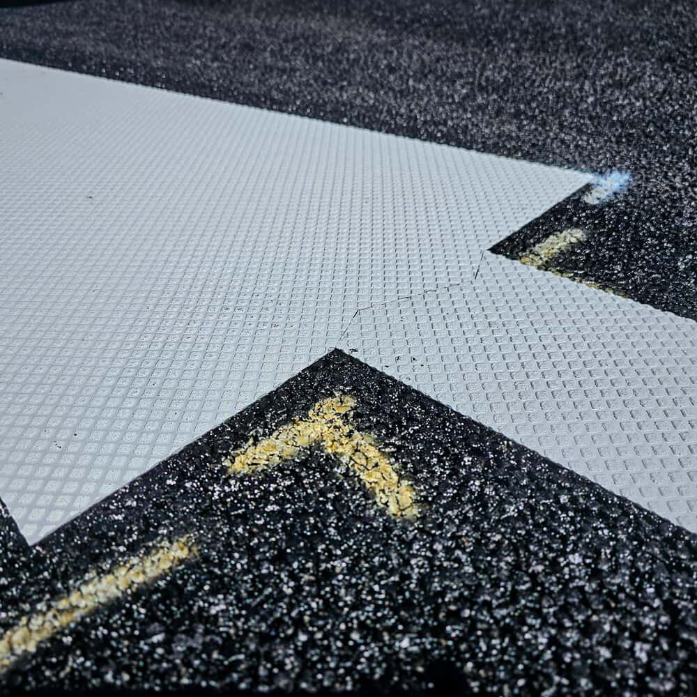 Detailansicht eines Richtungspfeils aus 3M Stamark A380 auf dunkler Asphaltoberfläche