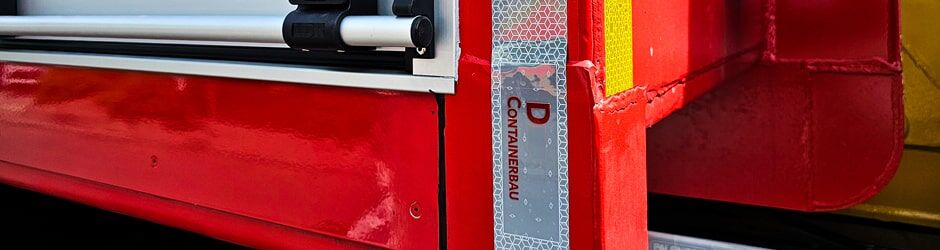 Nahaufnahme eines roten Einsatzfahrzeugs mit reflektierender Logo-Konturmarkierung.