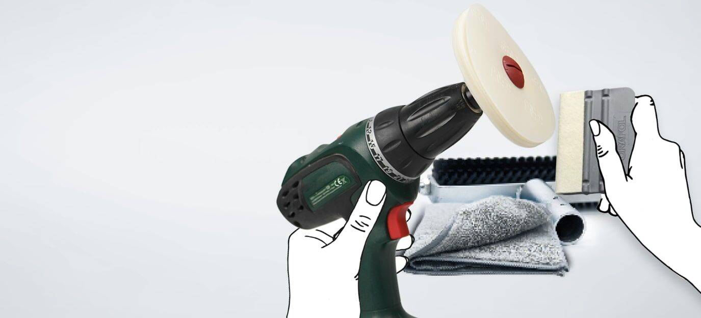 Akkubohrer mit Polierscheibe und Rakel vor Reinigungstüchern und Werkzeug.