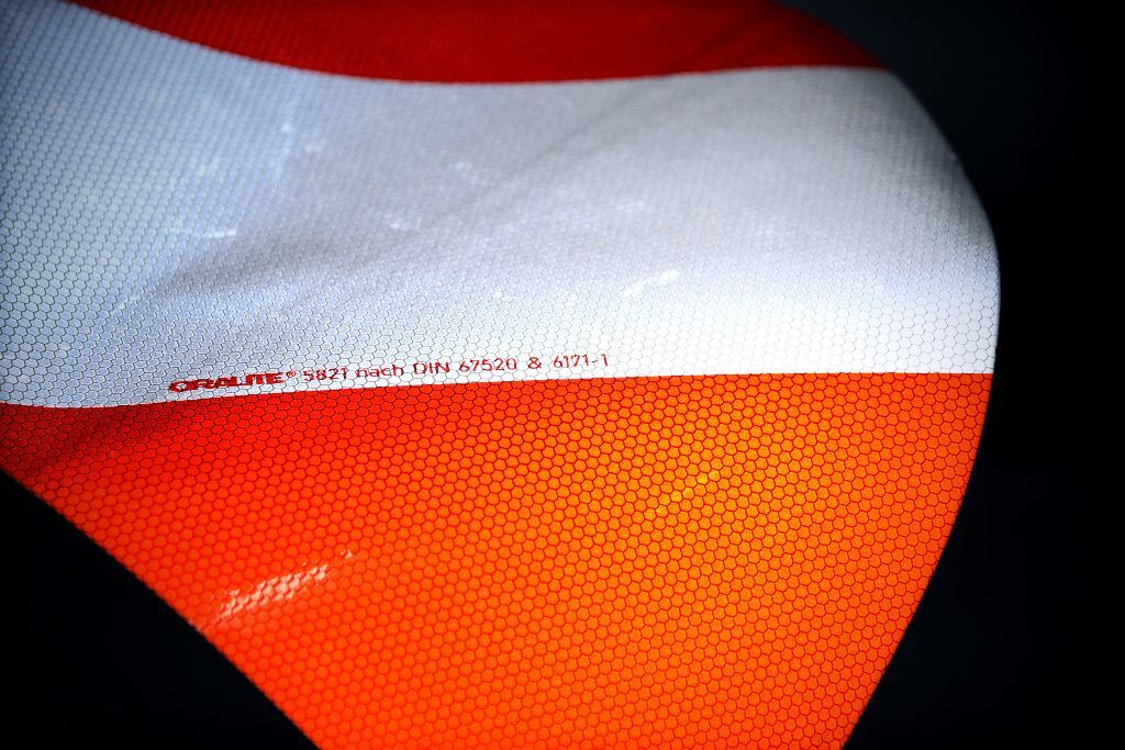 Reflektierende Folie im Licht mit rot-silbernem Muster und Wabenstruktur