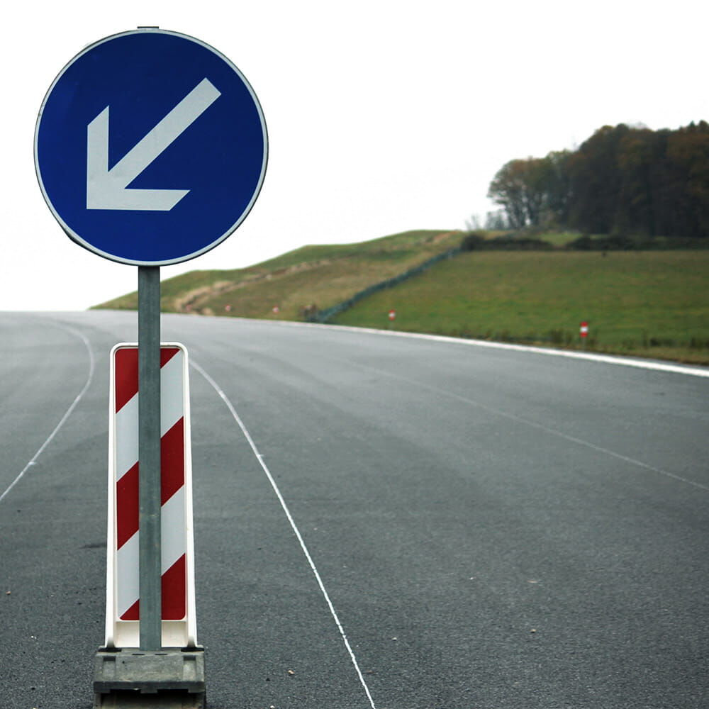 VZ 222-10 „Vorgeschriebene Vorbeifahrt links“ am Straßenleitpfosten