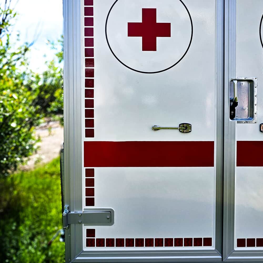 Rotes Kreuz und reflektierende Markierung auf weißer Fahrzeugtür