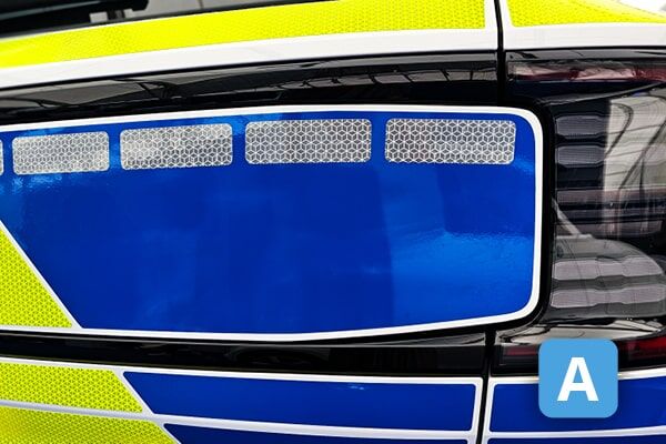 Nahaufnahme eines modernen LED-Scheinwerfers eines Polizeiautos mit blau-gelber Lackierung.