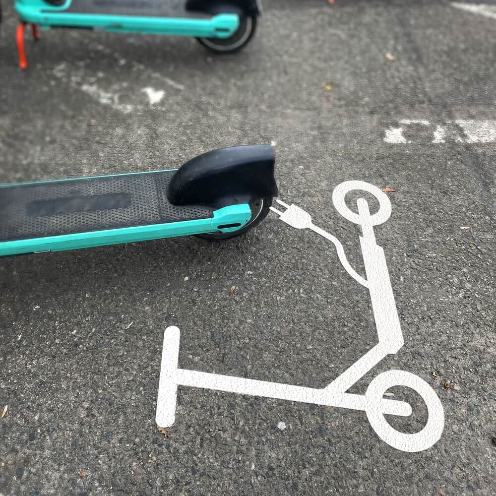 Weißes E-Scooter-Symbol als Bodenmarkierung, genutzt als Abstellfläche