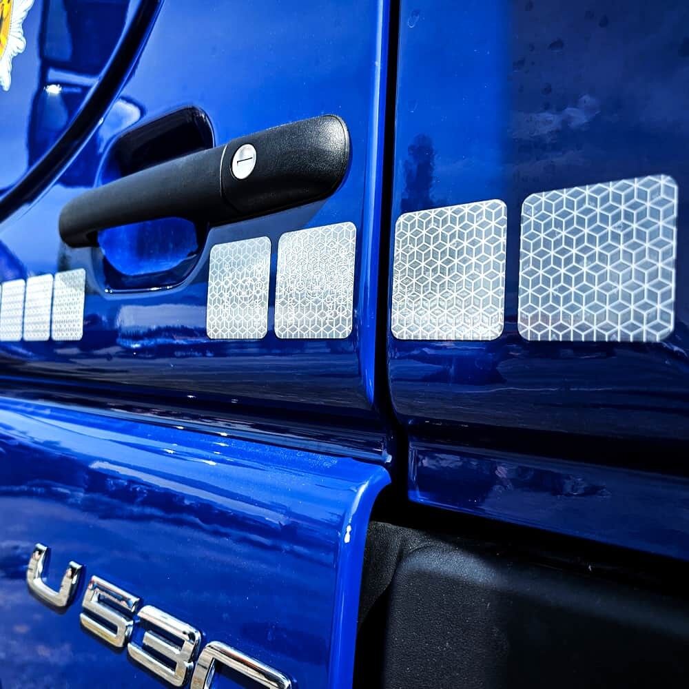 Rechteckige VC104+ CG Segmente auf blauer Lkw-Tür neben Türgriff appliziert