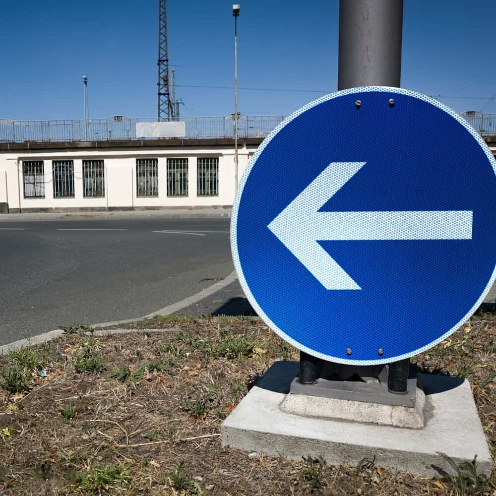 Montiertes VZ 211-10 Verkehrszeichen, Fahrtrichtung links, am Mast