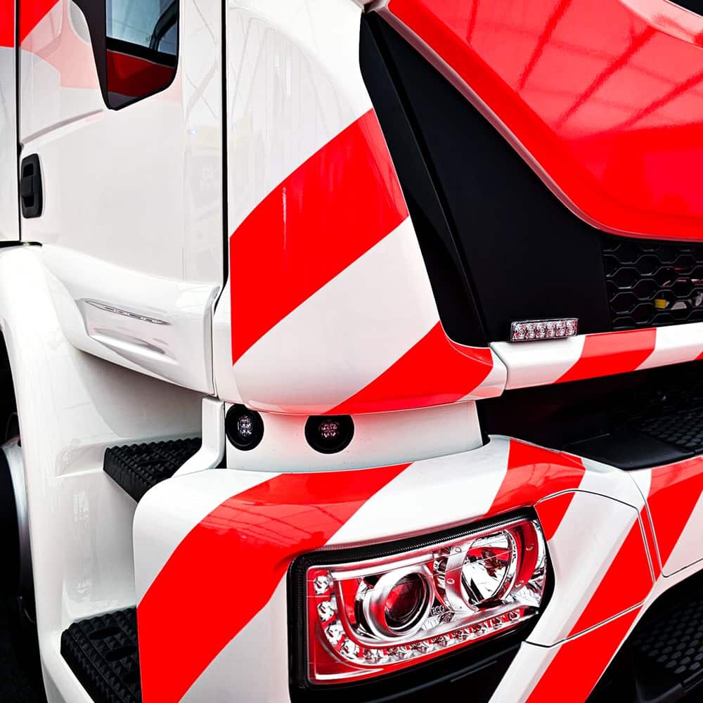 Lkw-Kabine mit schrägen roten Fluorstreifen 7710 auf weißem Fahrerhaus.