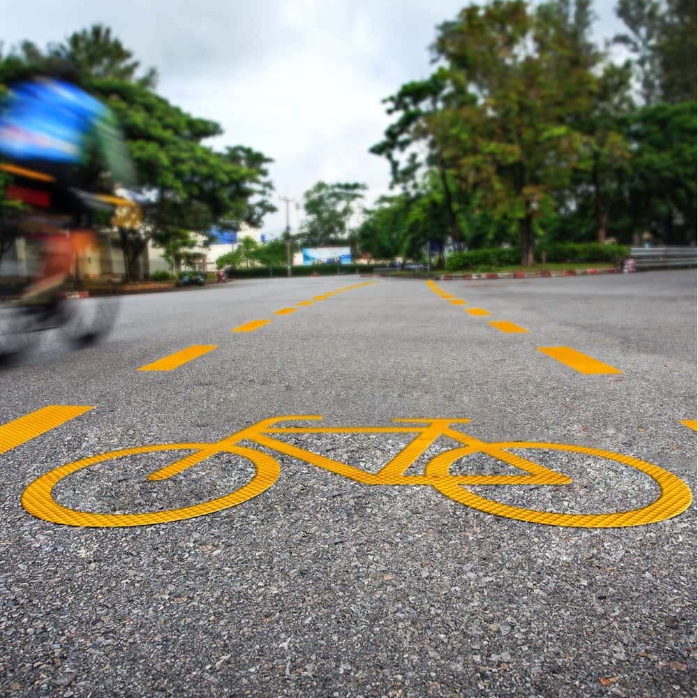 Gelbe Fahrbahnmarkierung mit Fahrrad-Symbol aus 3M Stamark A721, aufgebracht im Straßenraum
