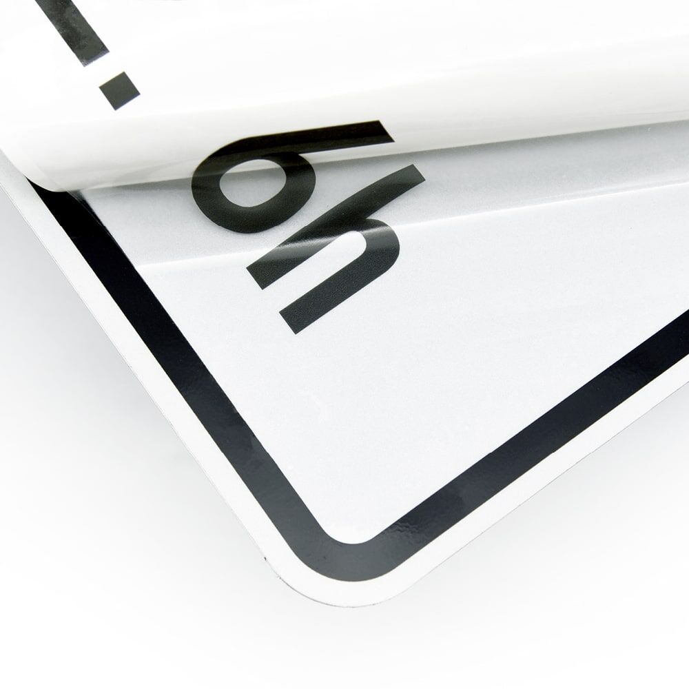 Transparentes Overlay wird abgezogen, schwarzer Aufdruck auf klarer Folie sichtbar