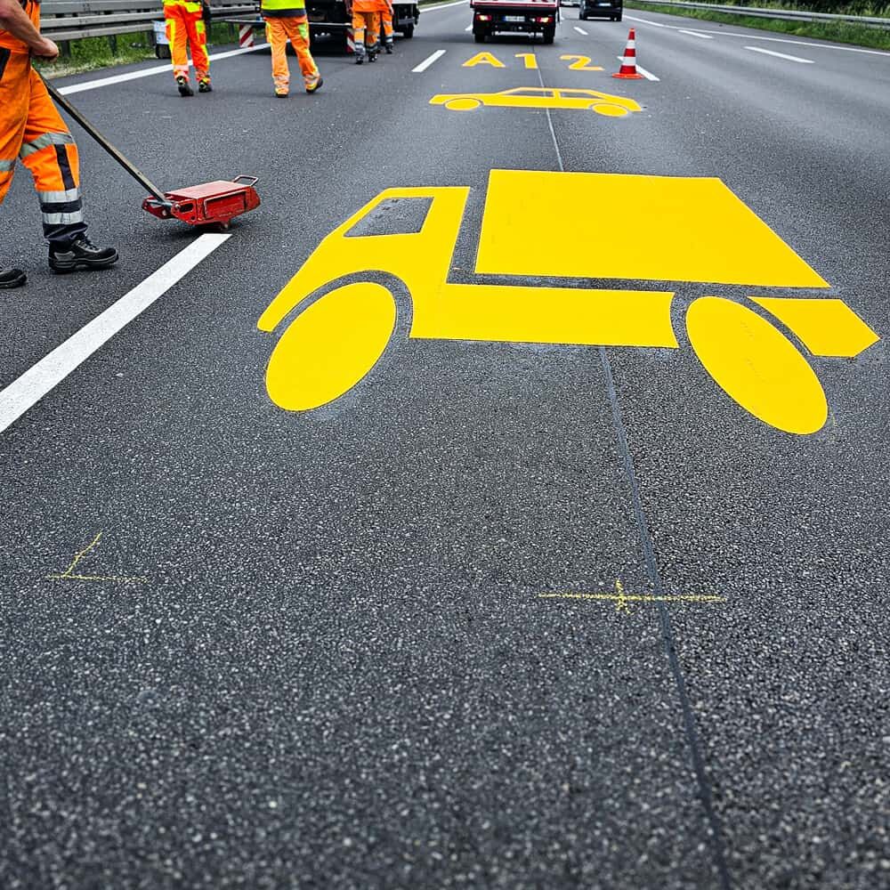 Aufbringen eines Lkw-Piktogramms aus 3M Stamark gelb auf Autobahnfahrstreifen