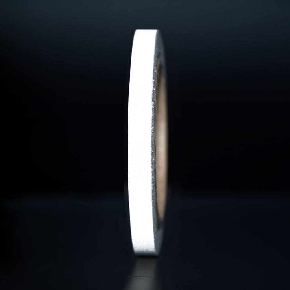 10 mm Rolle Orafol ORALITE Reflexband 5710 weiß, reflektierend vor dunklem Hintergrund