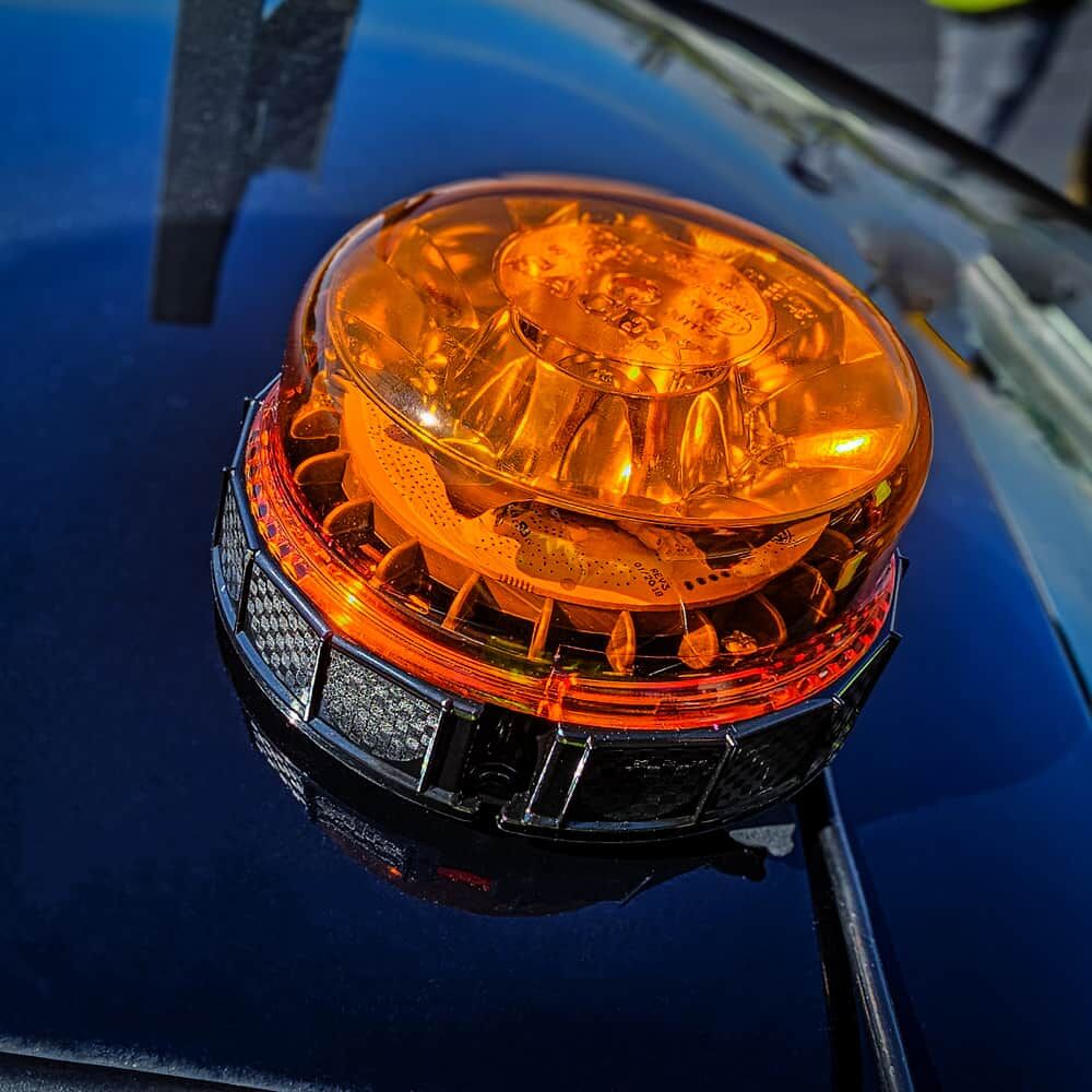 Obere Ansicht der LED-Rundumleuchte auf glänzendem Autodach bei Sonnenschein