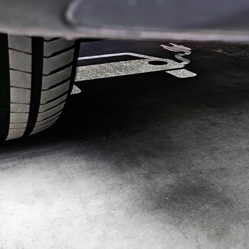 Reifen auf Bodenmarkierung mit Elektroauto-Symbol