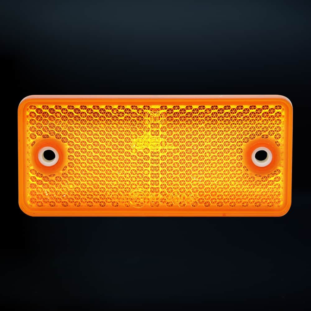 Oranger Reflektor 90×40 mm leuchtet vor dunklem Hintergrund