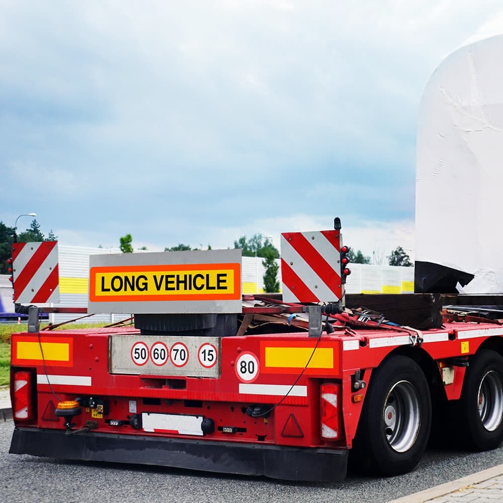 Heckansicht eines roten Schwertransporters mit montierter Long Vehicle Tafel